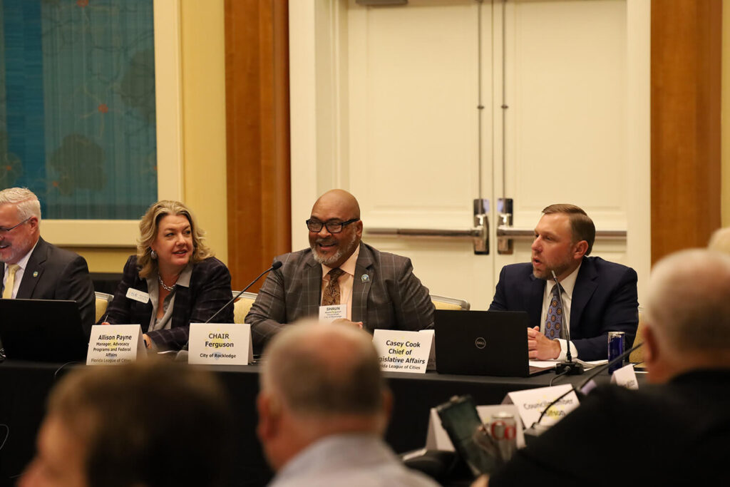 Committee members at a table addressing a crowd