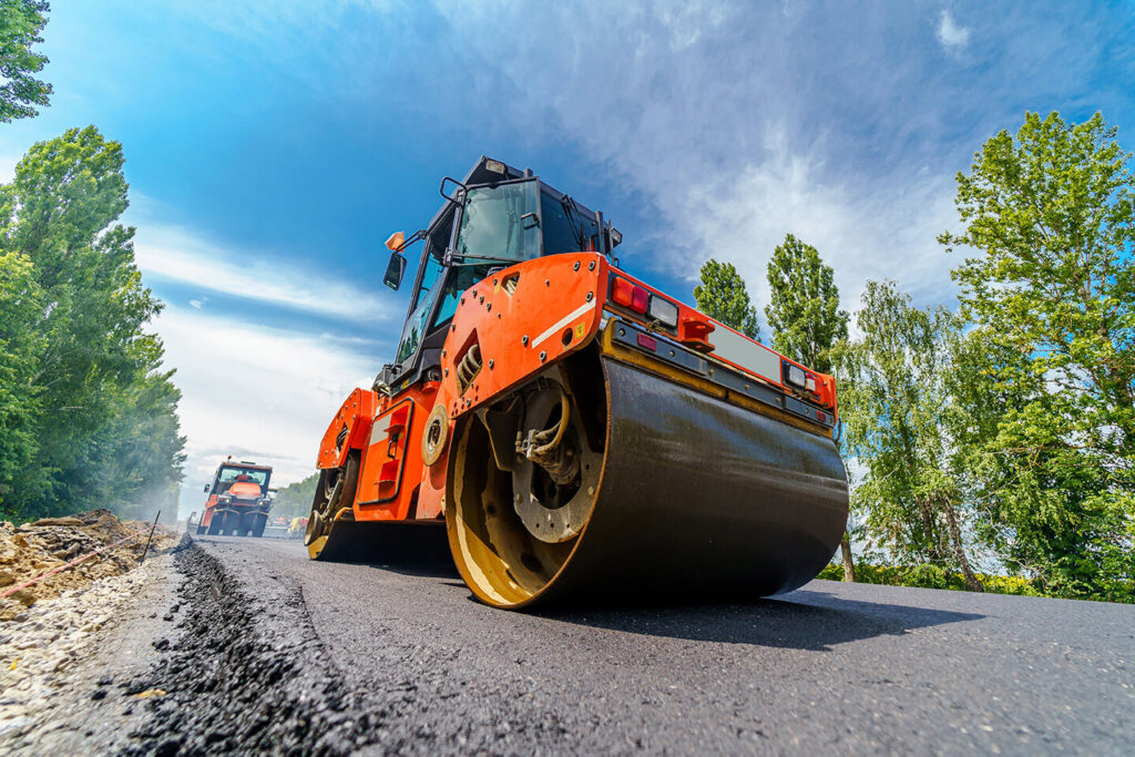 Heavy equipment rolling a new street