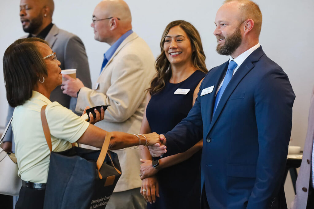 Several suited individuals shaking hands