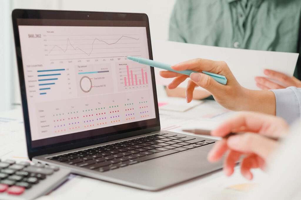 Technical assistance pointing at a graph on a laptop